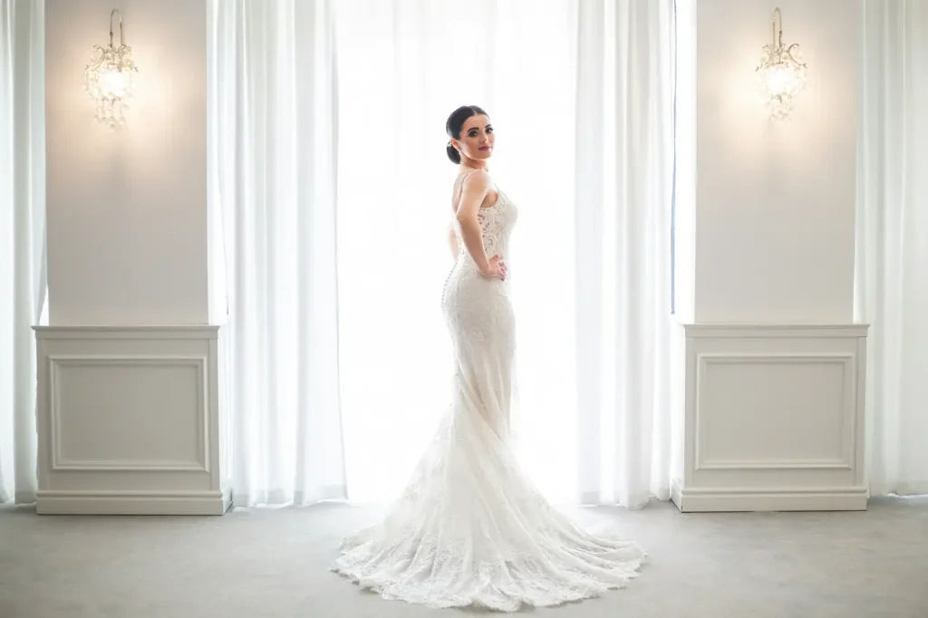 Panna młoda w eleganckiej sukni ślubnej z trenem w ogrodowym otoczeniu